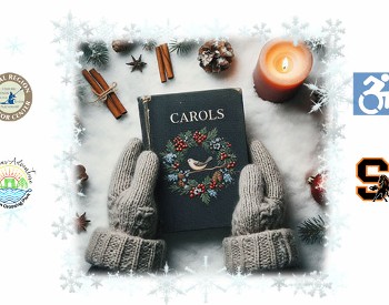 Two mittened hands are holding a book that says "Carols." Around the hands are a few cinnamon sticks, an anise star, and a candle.