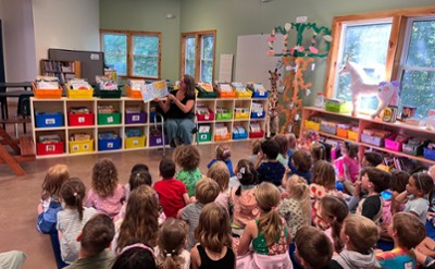 Lower school students enjoy story time on one of the 3 libraries at Saratoga Independent School