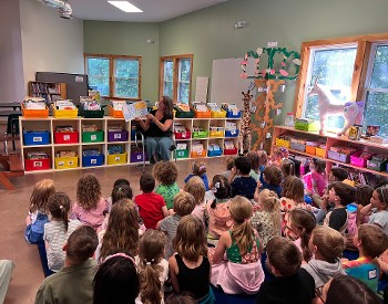 Lower school students enjoy story time on one of the 3 libraries at Saratoga Independent School