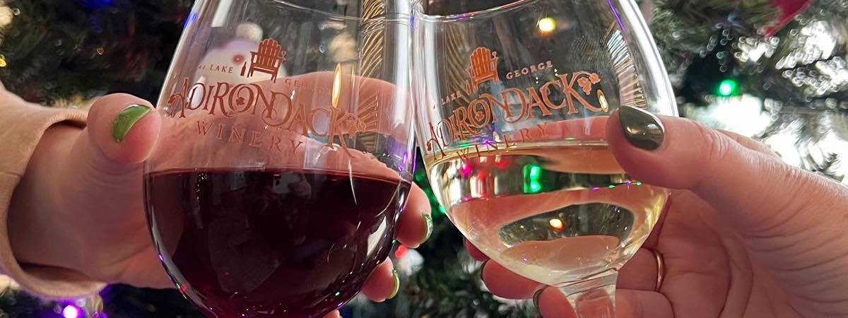 adirondack winery wine glasses cheersing in front of christmas tree