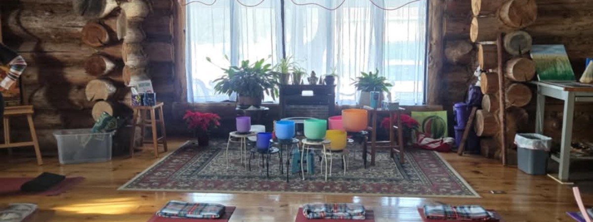 multi colored signing bowls on stands in a log cabin with yoga mats on the floor