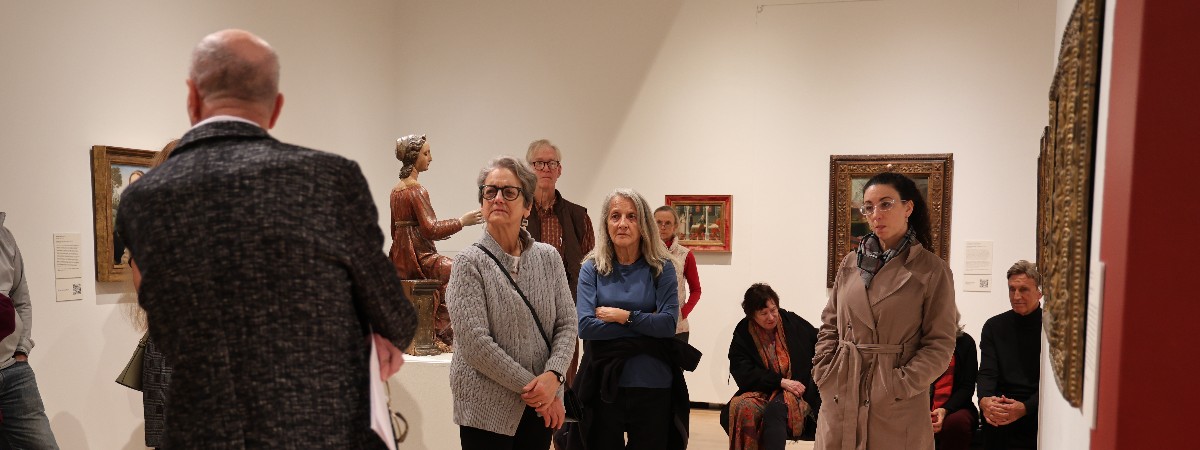 Visitors in the museum listen to a presenter.