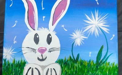 Painted white bunny with dandelions and grass