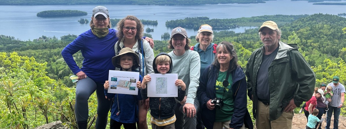 A group gathers at the Pinnacle overlook with Lake George in the background
