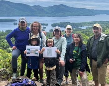 A group gathers at the Pinnacle overlook with Lake George in the background