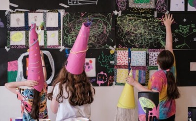 kids with handmade hats and art on the walls