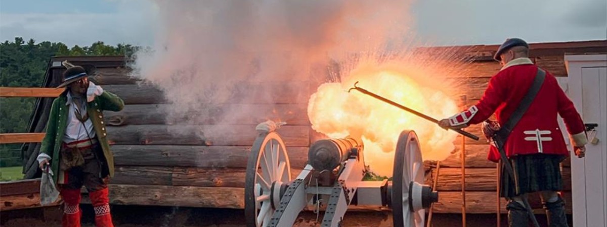 two reenactors lighting a canon