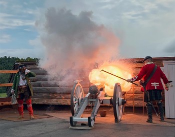 two reenactors lighting a canon