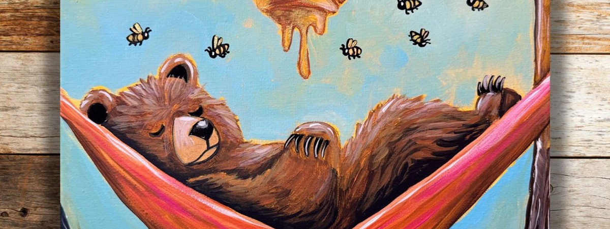 A bear sleeping in a hammock under a bee hive