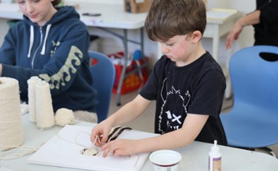 A child creates an artwork at The Hyde.