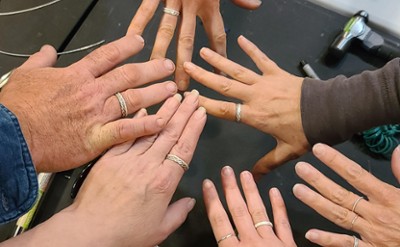 Six outstretched hands with silver rings