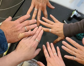 Six outstretched hands with silver rings