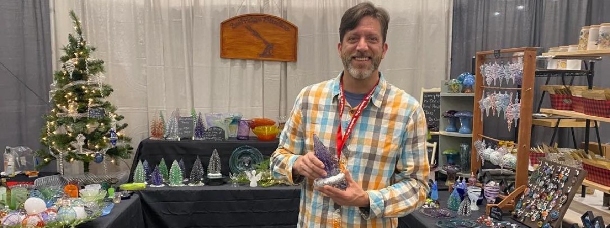 artist holding glass piece