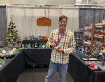 artist holding glass piece