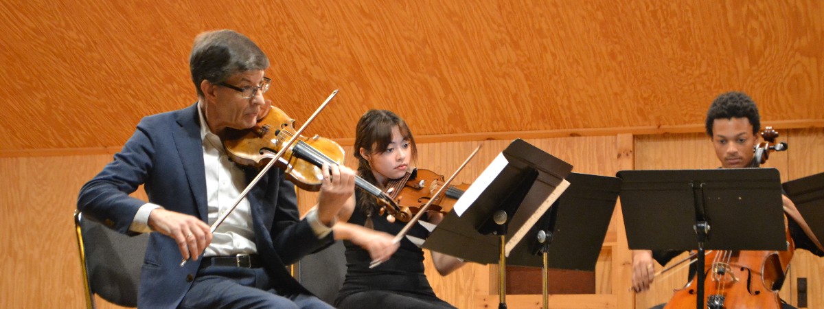 Two violinists and a cellist perform a concert