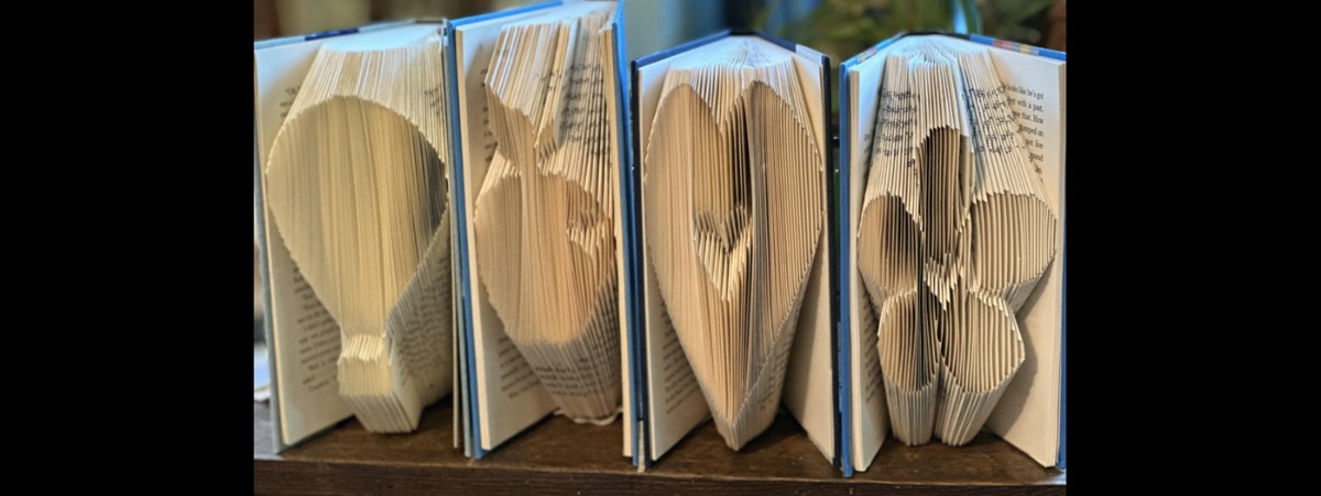 Four books folded on the page side to be a hot air balloon, apple, heart and flower