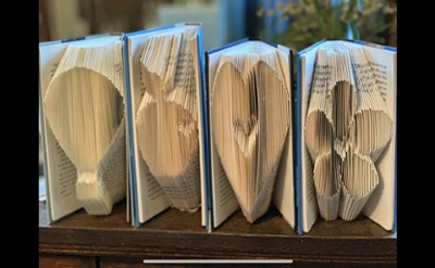 Four books folded on the page side to be a hot air balloon, apple, heart and flower