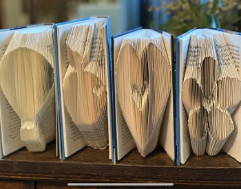 Four books folded on the page side to be a hot air balloon, apple, heart and flower