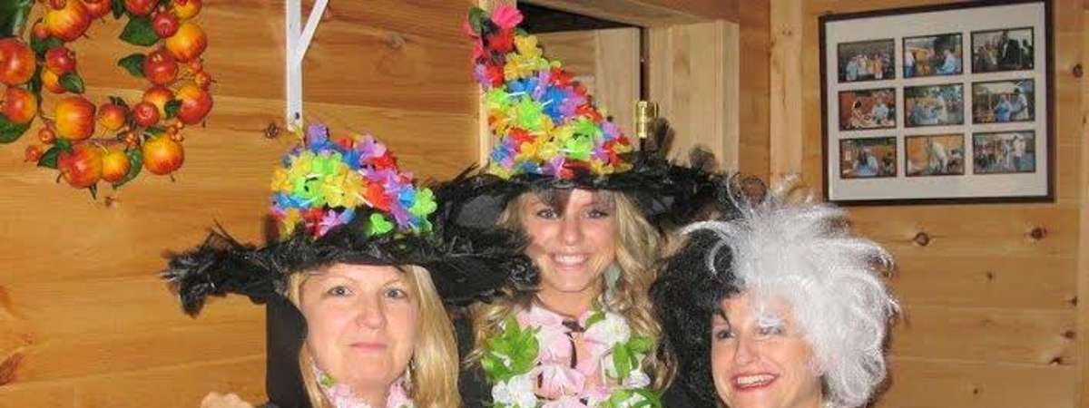 three women dressed up as witches for celebration