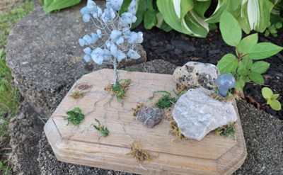 wire tree with crystals for leaves, on a wood base with rocks and moss