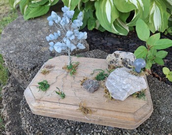 wire tree with crystals for leaves, on a wood base with rocks and moss