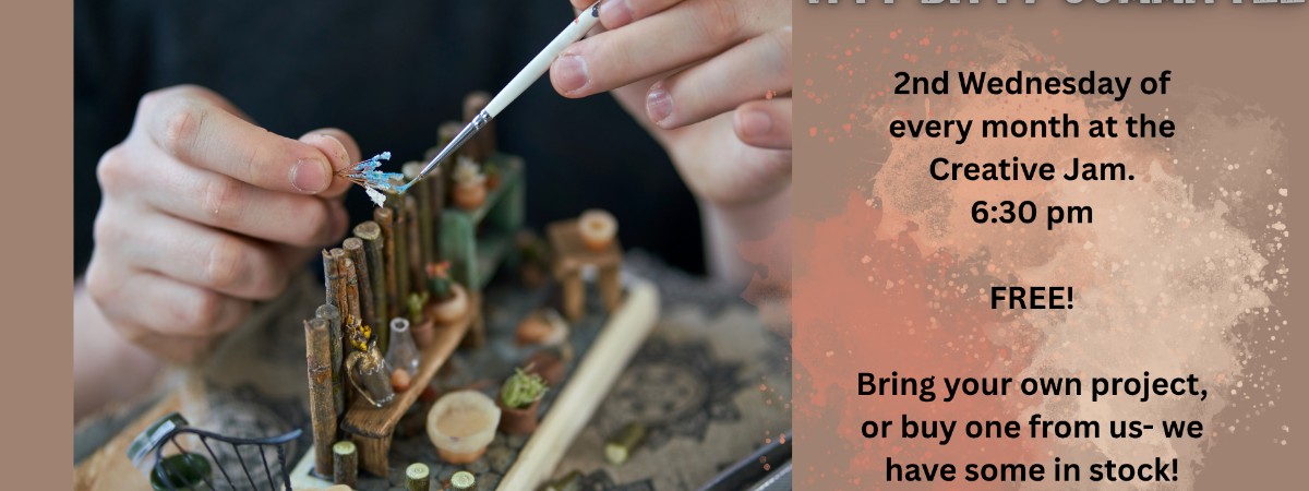 A pair of hands working to build a miniature scene