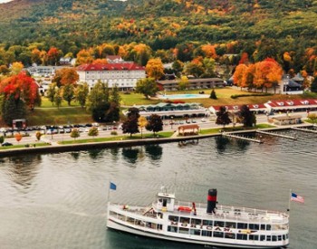 mohican steamboat on lake with fall colors on trees