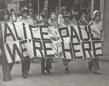 Suffragists carrying a banner