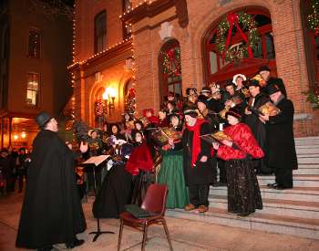 man leading carolers on church steps