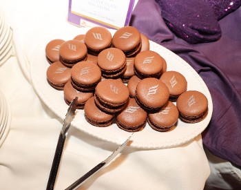 Chocolate macaroon pastries with EFNENY flame logo in silver on top