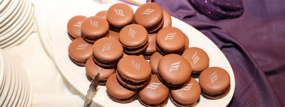 chocolate macaroons with EFNENY flame logo drawn on in silver