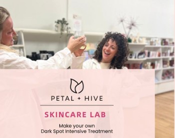 Two women cheering wearing lab coats