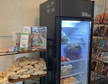 Photo of flyers and a refrigerator with food in it.