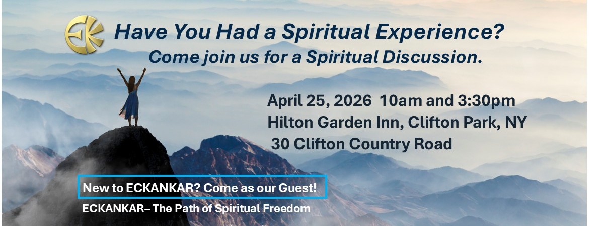 woman with arms raised on hilltop overlooking valley