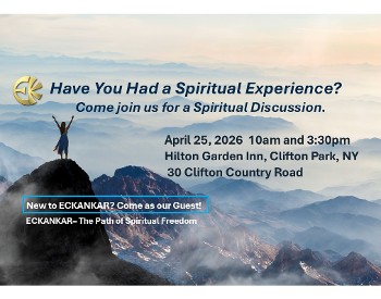 woman with arms raised on hilltop overlooking valley