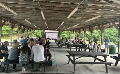 A crowd gathers around picnic tables
