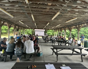 A crowd gathers around picnic tables