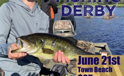 A young man in a boat holds up a large bass