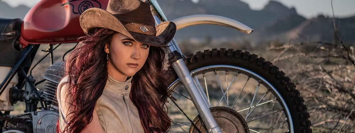 A singer sits in front of a motorcycle