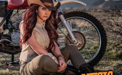 A singer sits in front of a motorcycle