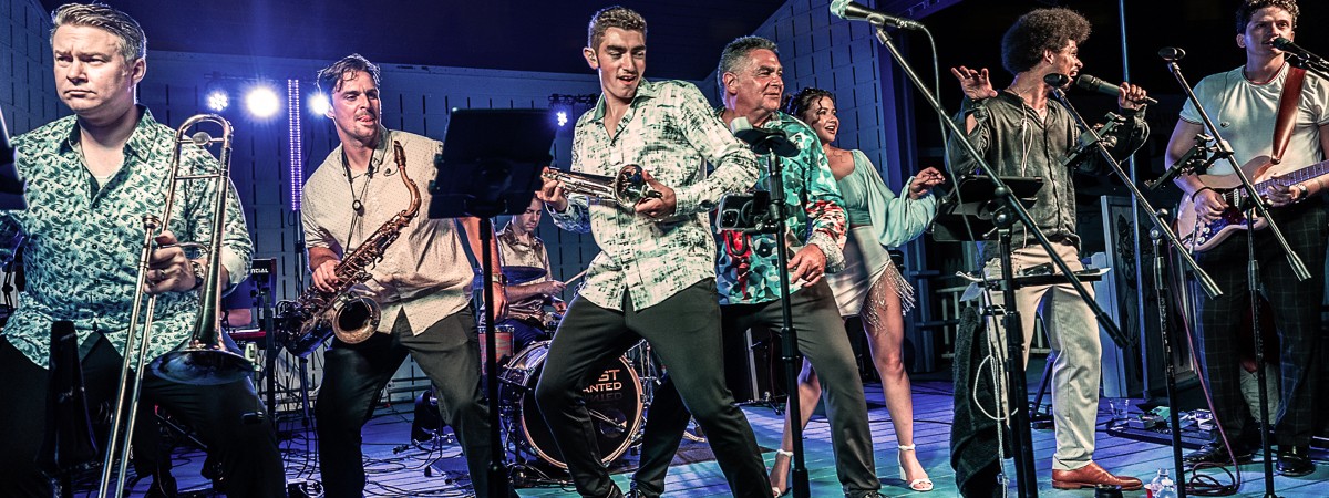 A large band plays and sings on stage