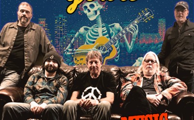A band poses for a photo in front of a Grateful Dead mural 