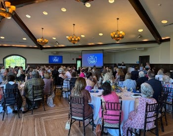 Room full of people watching a presentation