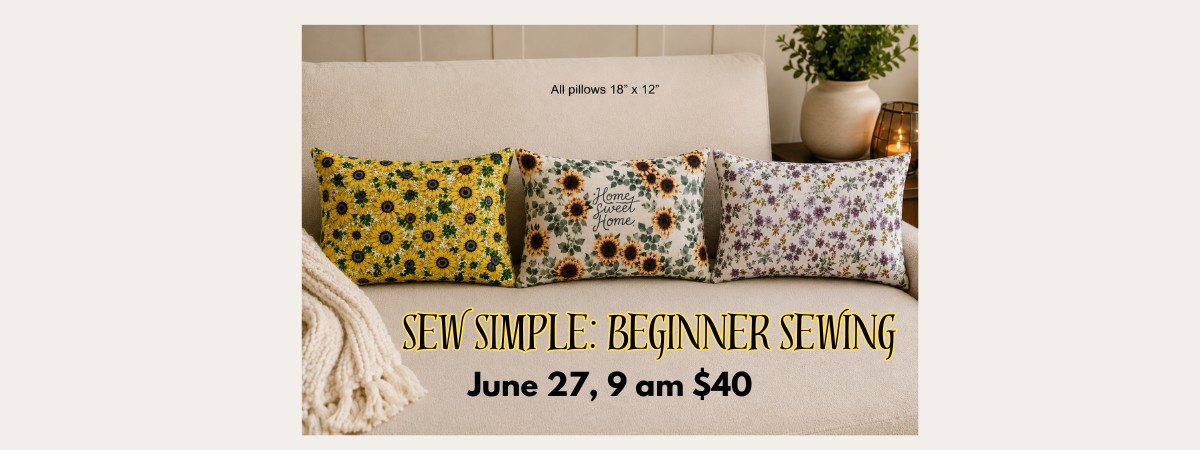 A couch with three rectangular pillows of differnt fabrics