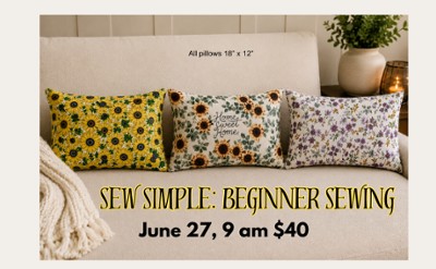 A couch with three rectangular pillows of differnt fabrics
