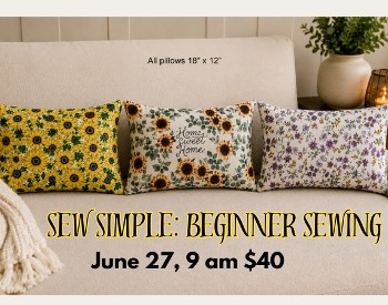 A couch with three rectangular pillows of differnt fabrics