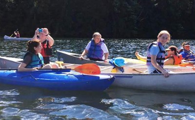 Friends in canoes and kayaks on Lakes Pond at Camp Little Notch
