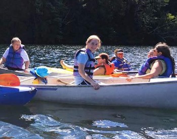 Friends in canoes and kayaks on Lakes Pond at Camp Little Notch