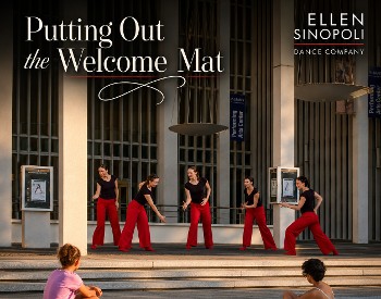 Five women in red pants and black shirts dance on the steps of a building with two children looking on.