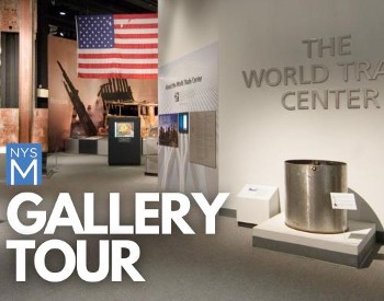 Text: Gallery Tour with World Trade Center artifacts in background